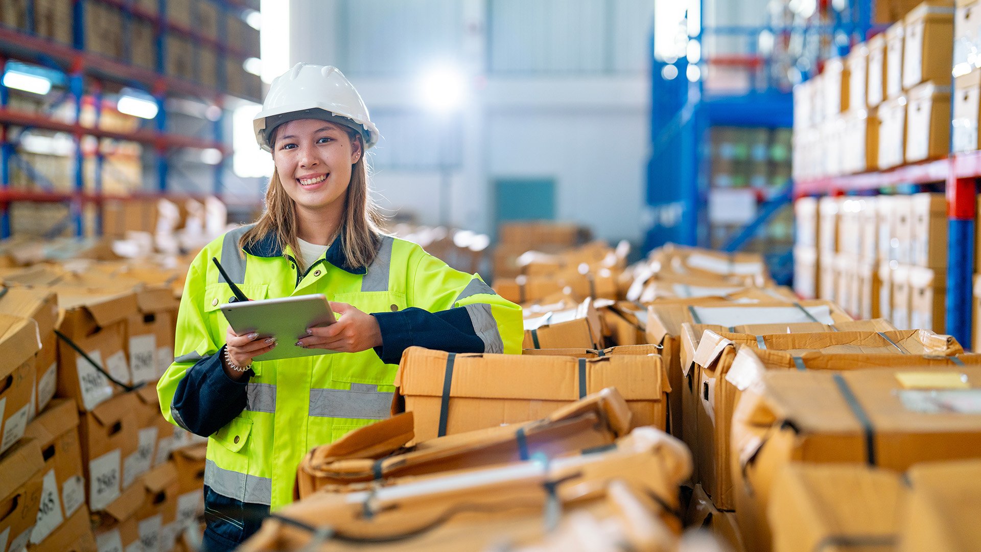 Eine Frau steht in einem Lager und hat einen Schreibblock in der Hand
