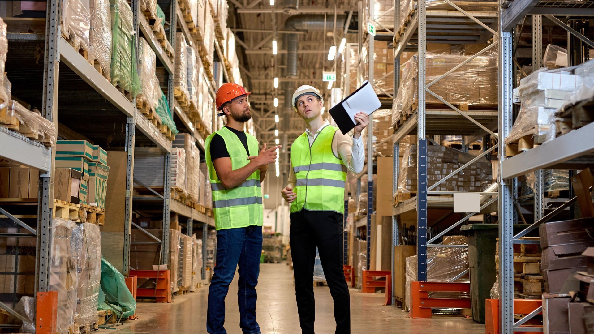 Zwei Warehouse-Manager besprechen sich im Lager Zwei Warehouse-Manager besprechen sich im Lager