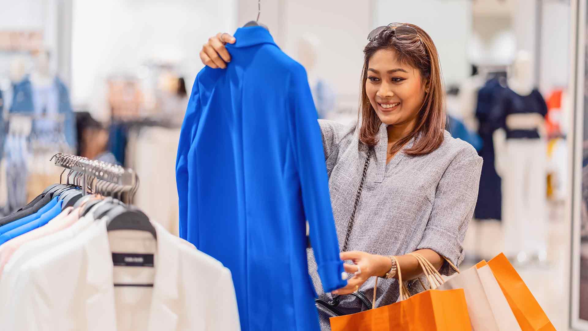 Frau schaut Kleidung in einem Einkaufsladen an