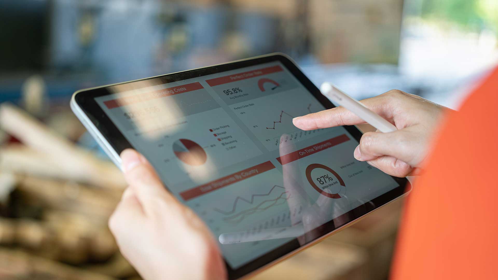 A tablet shows diagrams and graphics, hands edit them.