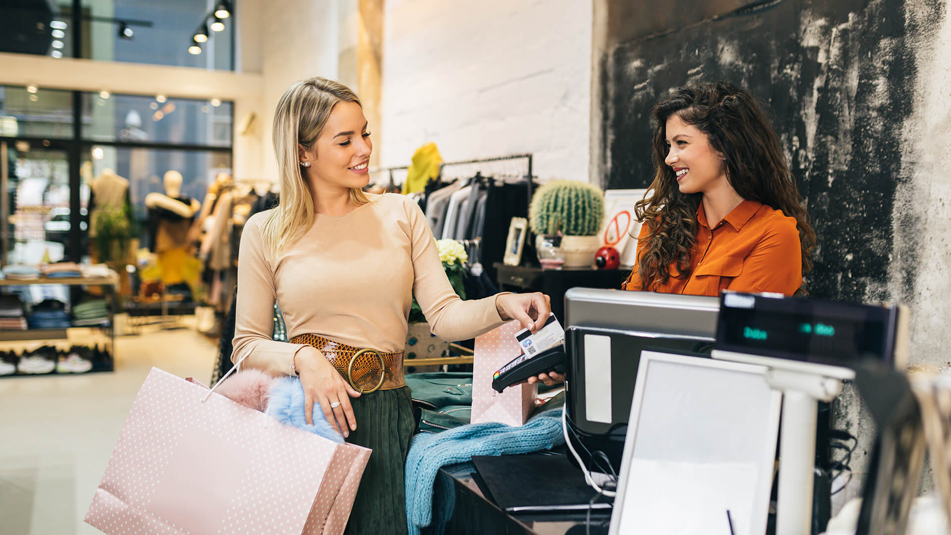 Frau bezahlt im Shop mit Kreditkarte